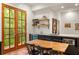 Kitchen with dark cabinets, wood table with chairs, wine fridge and french doors to the outside at 385 Anders N, Chattahoochee Hills, GA 30268