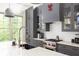 Close up of a modern kitchen featuring gray cabinetry, stone countertops, and stainless-steel appliances at 385 Anders N, Chattahoochee Hills, GA 30268