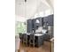 Open kitchen featuring gray cabinets, a central island with seating, and stainless-steel appliances at 385 Anders N, Chattahoochee Hills, GA 30268