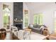 Bright living room with stone fireplace, vaulted ceiling, and large windows showcasing wooded views at 385 Anders N, Chattahoochee Hills, GA 30268