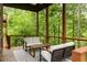 Inviting covered porch features comfortable seating, scenic views of the surrounding woods and ceiling fan at 385 Anders N, Chattahoochee Hills, GA 30268