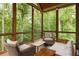 Relaxing screened porch with wicker furniture and a view of the surrounding forest at 385 Anders N, Chattahoochee Hills, GA 30268