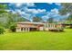 Expansive backyard featuring a spacious green lawn, mature trees, and a deck, perfect for outdoor activities at 8140 Wood St Se, Covington, GA 30014