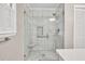 Modern bathroom featuring a glass-enclosed shower with white tile, a built-in seat, and grab bars at 8140 Wood St Se, Covington, GA 30014