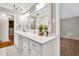 Bright bathroom vanity with white countertop, drawers, a large mirror, and decorative light fixtures at 8140 Wood St Se, Covington, GA 30014