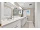 Bright bathroom featuring a white vanity with a large mirror and a charming chandelier, offering a refreshing space at 8140 Wood St Se, Covington, GA 30014