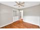 Light and airy bedroom featuring hardwood floors, a ceiling fan, and a large closet with folding doors at 8140 Wood St Se, Covington, GA 30014
