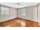 Charming bedroom with hardwood floors, neutral walls, ceiling fan, and windows with mini-blinds at 8140 Wood St Se, Covington, GA 30014