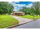 Well-maintained brick home with a long driveway and spacious front yard, surrounded by trees at 8140 Wood St Se, Covington, GA 30014