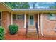 Charming brick home featuring a covered front porch with decorative columns and a well-manicured garden at 8140 Wood St Se, Covington, GA 30014