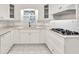 Bright kitchen boasts stainless appliances, white cabinetry, and hexagonal tile flooring at 8140 Wood St Se, Covington, GA 30014