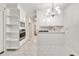 Bright kitchen with white cabinetry, stainless appliances, and stylish chandelier lighting at 8140 Wood St Se, Covington, GA 30014