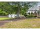 Large backyard featuring a charming shed, deck, and mature trees at 1450 Walker Se St, Smyrna, GA 30080