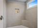 Modern bathroom shower with gray tiling, built-in seat, and convenient shelving niche at 1450 Walker Se St, Smyrna, GA 30080
