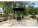Wooden deck featuring an umbrella-shaded dining area surrounded by lush trees at 1450 Walker Se St, Smyrna, GA 30080