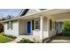 Inviting home exterior featuring a blue door, manicured lawn, and covered parking at 1450 Walker Se St, Smyrna, GA 30080