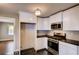 Kitchen area featuring updated appliances, white cabinets, and dark countertops at 1450 Walker Se St, Smyrna, GA 30080