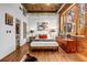 Inviting bedroom featuring hardwood floors, exposed brick, and a large window with natural light at 3235 Roswell Ne Rd # 508, Atlanta, GA 30305