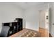A clean, simple bedroom provides access to a bathroom, featuring a hardwood floor and a small black shelving unit at 553 Collingwood Dr, Decatur, GA 30032