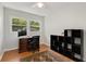 Bedroom features a ceiling fan, a window letting in natural light, a wooden desk, and a black shelving unit at 553 Collingwood Dr, Decatur, GA 30032