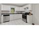 A bright kitchen with white cabinets, stainless steel appliances, granite counter tops and white tile floors at 553 Collingwood Dr, Decatur, GA 30032