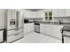 Bright eat-in kitchen with stainless steel appliances, white cabinets, gray counter tops and white tile floors at 553 Collingwood Dr, Decatur, GA 30032