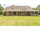 A great covered patio overlooks a well-manicured lawn, ideal for entertaining and leisure at 100 Marshas Vineyard, Hampton, GA 30228