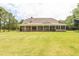 Expansive backyard featuring a covered porch, perfect for outdoor relaxation and entertainment at 100 Marshas Vineyard, Hampton, GA 30228