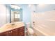 Bathroom featuring blue walls, shower/tub combo, toilet, and vanity with a dark wood cabinet at 100 Marshas Vineyard, Hampton, GA 30228
