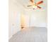 Bedroom with neutral walls, plush carpet, hallway access, and a modern ceiling fan at 100 Marshas Vineyard, Hampton, GA 30228