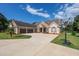 Traditional brick home with a three-car garage, manicured lawn, and a basketball hoop, perfect for Gathering fun at 100 Marshas Vineyard, Hampton, GA 30228