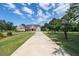 Charming brick home with a long driveway, meticulously maintained lawn, and lush landscaping, creating a welcoming atmosphere at 100 Marshas Vineyard, Hampton, GA 30228