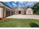 Beautiful brick home with a manicured lawn, three-car garage, and a welcoming entrance, exuding charm and curb appeal at 100 Marshas Vineyard, Hampton, GA 30228