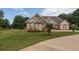 Charming brick home with a lush green lawn, beautiful landscaping, and a circular driveway at 100 Marshas Vineyard, Hampton, GA 30228