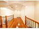 Hallway with rich hardwood floors, wooden railings, and elegant architectural details at 100 Marshas Vineyard, Hampton, GA 30228