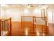 Hallway with hardwood floors, wooden railings, mirror, and elegant architectural details at 100 Marshas Vineyard, Hampton, GA 30228