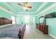 Spacious main bedroom featuring a ceiling fan, tray ceiling, and wood floors at 100 Marshas Vineyard, Hampton, GA 30228