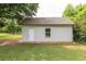 Outbuilding with painted siding, shingles, and a single window nestled in a grassy area near mature trees at 100 Marshas Vineyard, Hampton, GA 30228