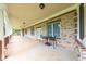 Large covered porch featuring brick accents, outdoor lighting, and an area for seating at 100 Marshas Vineyard, Hampton, GA 30228