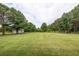 A vast green yard features mature trees and a storage shed, offering ample outdoor space at 100 Marshas Vineyard, Hampton, GA 30228