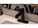Modern bathroom faucet and countertop with patterned wallpaper in background at 3116 Jackson St, Hapeville, GA 30354