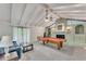 Open living room with fireplace, vaulted ceiling, lots of natural light and a pool table at 3553 Lakeview Dr, Rex, GA 30273