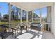 Relaxing screened-in sunroom with cozy seating and views of the surrounding landscape at 3891 Shelleydale Dr, Powder Springs, GA 30127