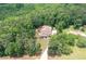 A distant aerial view showcasing a home surrounded by lush trees with a backyard pool and a long driveway at 7131 Ridge Rd, Hiram, GA 30141