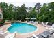 Stunning backyard pool with a stone surround, waterfall feature, and ample seating for entertaining at 7131 Ridge Rd, Hiram, GA 30141