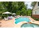 This backyard features a kidney-shaped pool with a spa and an expansive patio with lounge chairs and umbrellas at 7131 Ridge Rd, Hiram, GA 30141