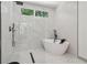 Beautiful bathroom features a soaking tub and marble-style tile in shower at 1129 Victory Sw Dr, Atlanta, GA 30310