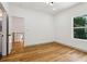 A bright bedroom featuring hardwood floors, white walls, and easy access to the staircase at 1129 Victory Sw Dr, Atlanta, GA 30310