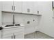 Laundry room with white cabinets, black hardware, and floral pattern tile floor at 1129 Victory Sw Dr, Atlanta, GA 30310