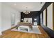 Main bedroom with hardwood floors, modern lighting fixture, and adjacent en-suite bathroom at 1129 Victory Sw Dr, Atlanta, GA 30310